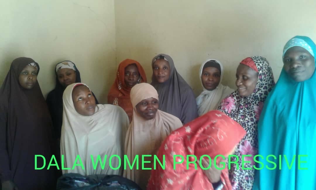Women standing with food supplies after a distribution