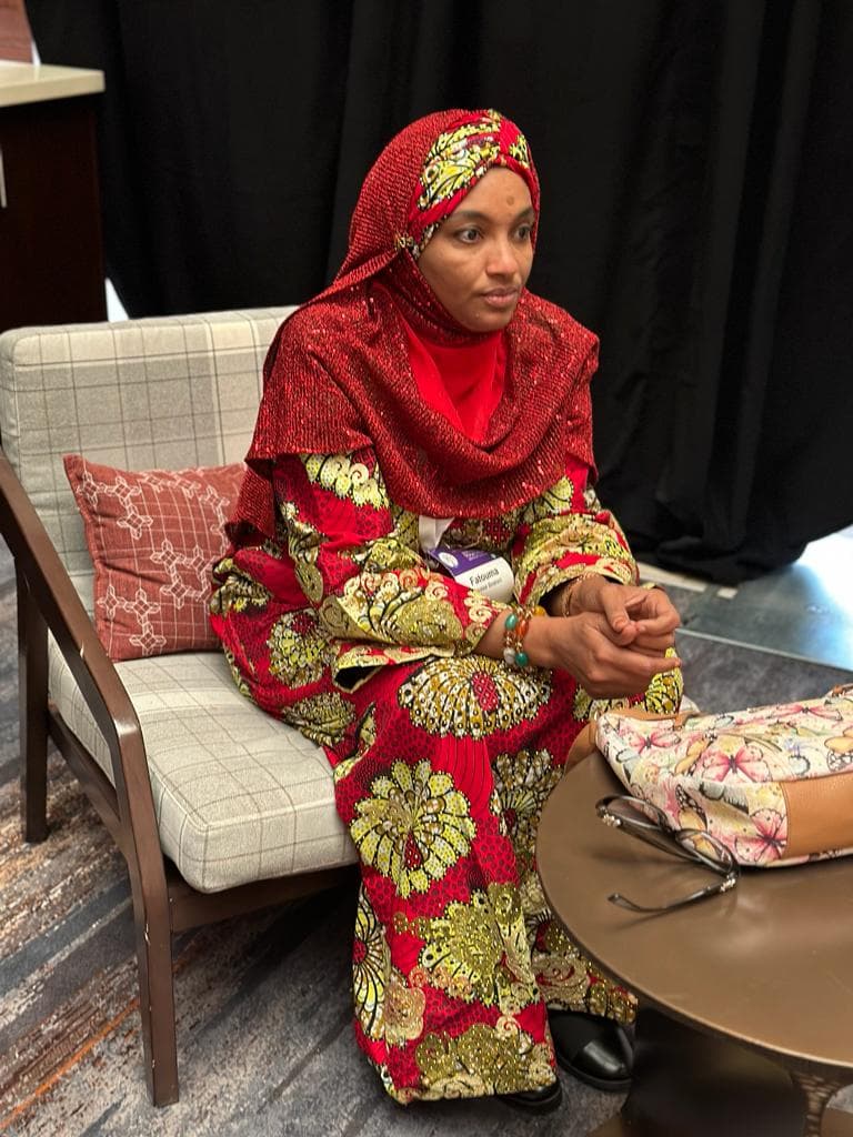 Portrait of Fatouma Moussa Ibrahim in a red hijab and patterned dress
